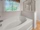 Bright bathroom featuring a soaking tub, a walk-in shower, and a window providing natural light at 5404 Red Fork Ln, North Charleston, SC 29420