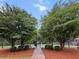 Tennis court entrance framed by trees and decorative mulch beds at 5404 Red Fork Ln, North Charleston, SC 29420