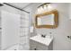 Bathroom with a walk-in shower, modern vanity, and a stylish wicker mirror at 718 Parish Rd, Charleston, SC 29407