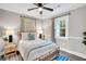 Cozy bedroom with paneled walls, neutral bedding, and a ceiling fan for added comfort at 718 Parish Rd, Charleston, SC 29407
