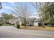 Well-maintained home with mature trees, lush landscaping, a paved driveway, and a separate garage at 718 Parish Rd, Charleston, SC 29407