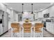 Well-lit kitchen with island seating, stainless steel refrigerator, and modern white cabinets at 718 Parish Rd, Charleston, SC 29407