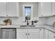 Close-up of kitchen sink with modern faucet, white cabinets, and stylish backsplash at 718 Parish Rd, Charleston, SC 29407