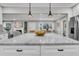Modern kitchen features marble island with pendant lights, stainless steel refrigerator, and open layout to living spaces at 718 Parish Rd, Charleston, SC 29407