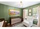 Comfortable green-painted Bedroom featuring a wooden crib, plush glider, and decorative artwork at 638 Stono Edge Dr, Charleston, SC 29412