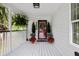 Inviting covered front porch with a decorative front door and stylish potted plants on a wood deck at 638 Stono Edge Dr, Charleston, SC 29412