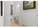 Half bathroom with hardwood floors, a pedestal sink, and artwork of a farm with sunflowers at 716 Triangle Ln, Summerville, SC 29486