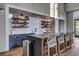 Clubhouse kitchen featuring stone countertops, bar seating, decorative tile, shelving, and a stainless steel trash can at 716 Triangle Ln, Summerville, SC 29486