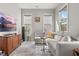 Sunlit living room showcasing a gray sectional, a wooden media console, and a modern aesthetic at 716 Triangle Ln, Summerville, SC 29486