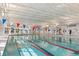Bright indoor swimming pool featuring lap lanes, clear blue water, lifeguard, and colorful pennant flags at 740 Blue Iris Way, Summerville, SC 29486
