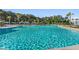 Large outdoor community pool with clear turquoise water, lounge chairs and umbrellas and lush landscaping at 740 Blue Iris Way, Summerville, SC 29486