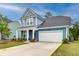 Charming two-story home with a white garage, a well-manicured lawn, and a welcoming front porch at 802 S Pointe Blvd, Summerville, SC 29483
