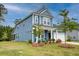 Charming two-story blue home featuring a landscaped yard, attached garage, and welcoming front porch seating at 802 S Pointe Blvd, Summerville, SC 29483