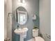 Stylish half bathroom with pedestal sink, decorative mirror, and seashell artwork on blue painted walls at 802 S Pointe Blvd, Summerville, SC 29483
