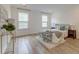 Bright main bedroom featuring two windows, light hardwood floors, and a comfortable bed with decorative pillows at 802 S Pointe Blvd, Summerville, SC 29483