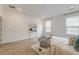 Airy bedroom with a light hardwood floor, two windows, and a bed with decorative pillows and throw at 802 S Pointe Blvd, Summerville, SC 29483
