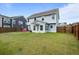 Expansive backyard with lush lawn, wooden fence, and two-story home with sunroom for outdoor enjoyment at 8402 Loggers Run, North Charleston, SC 29420