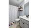 Bathroom featuring a vanity with black faucet, patterned shower curtain, and wood floating shelves with décor at 8402 Loggers Run, North Charleston, SC 29420