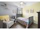 View of a cute bedroom with neutral walls, wood floors, toddler bed, white chair, and decorative shelves at 8402 Loggers Run, North Charleston, SC 29420