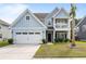 Charming two-story home with blue siding, a front porch balcony, and a well-maintained front yard at 8402 Loggers Run, North Charleston, SC 29420