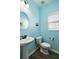 Bright half bathroom with blue walls, a pedestal sink, and a toilet at 8402 Loggers Run, North Charleston, SC 29420