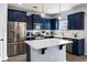 Well-lit kitchen with stainless steel appliances, navy cabinets, an island with white countertop and modern light fixtures at 8402 Loggers Run, North Charleston, SC 29420