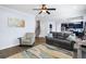 Open concept living room with a cozy sofa, hardwood floors, and access to the kitchen at 8402 Loggers Run, North Charleston, SC 29420