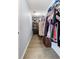View of a well-organized walk-in closet with custom shelving and ample storage space with laminate flooring at 8402 Loggers Run, North Charleston, SC 29420