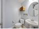 Cozy powder room featuring a pedestal sink, round mirror, and rustic crate shelving at 9019 Parlor Dr, Ladson, SC 29456