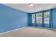 Bright blue bedroom with ample natural light and plush carpet at 9998 Winged Elm St, Ladson, SC 29456