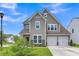 Well-maintained two-story home showcases a two-car garage, lush green lawn, and inviting curb appeal at 9998 Winged Elm St, Ladson, SC 29456