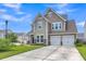 Charming two-story home featuring a two-car garage, stone accents, neutral siding, and well-manicured lawn at 9998 Winged Elm St, Ladson, SC 29456