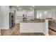 Well-lit kitchen with white cabinets, stainless steel appliances, and a granite-topped island at 9998 Winged Elm St, Ladson, SC 29456