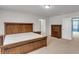 The main bedroom with neutral carpeting and a wooden bed set is naturally lit at 9998 Winged Elm St, Ladson, SC 29456