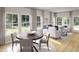Bright and airy living room with hardwood floors, stylish furniture, and large windows overlooking the backyard at 1013 Swamp Rose Run, Summerville, SC 29485