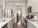 Stylish kitchen featuring stainless steel appliances, light gray cabinets, and hardwood floors leading to the dining area at 105 Indigo Cove Blvd, Summerville, SC 29486