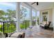 Spacious back porch with comfortable seating and scenic water views, framed by white pillars and a black railing at 108 Fairbanks Oak Aly # 201, Charleston, SC 29492