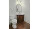 This traditional half-bath features hardwood floors, a wood vanity, and classic fixtures at 108 Fairbanks Oak Aly # 201, Charleston, SC 29492