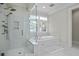 Bright bathroom featuring a tiled shower, soaking tub, and natural light at 108 Fairbanks Oak Aly # 201, Charleston, SC 29492