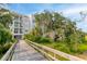Scenic view of a walkway leading to modern buildings with balconies, surrounded by greenery at 108 Fairbanks Oak Aly # 201, Charleston, SC 29492