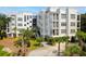 Beautiful white condo building with palm trees and manicured landscaping at 108 Fairbanks Oak Aly # 201, Charleston, SC 29492