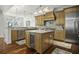 Well-equipped kitchen featuring wood cabinets, granite countertops, and a central island with a wine fridge at 108 Fairbanks Oak Aly # 201, Charleston, SC 29492