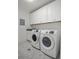 A well-equipped laundry room with granite counters, ample cabinet storage, and tile flooring at 108 Fairbanks Oak Aly # 201, Charleston, SC 29492