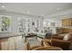 Cozy living room with a comfortable gray sofa, wood coffee table, and view into the modern kitchen at 108 Fairbanks Oak Aly # 201, Charleston, SC 29492