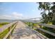 Scenic view of a wooden pier leading to the water with a distant bridge and lush greenery at 108 Fairbanks Oak Aly # 201, Charleston, SC 29492