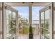 Picturesque view from the balcony through open French doors, overlooking the water and dock at 108 Fairbanks Oak Aly # 302, Daniel Island, SC 29492