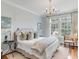 Light-filled bedroom boasts a decorative chandelier, large windows, and neutral decor at 108 Fairbanks Oak Aly # 302, Daniel Island, SC 29492