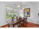 Bright dining room with hardwood floors, a rustic wooden table, and a view of the outdoors at 108 Fairbanks Oak Aly # 302, Daniel Island, SC 29492
