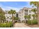 Lowcountry-style condo building with manicured landscaping, mature palms, and covered parking at 108 Fairbanks Oak Aly # 302, Daniel Island, SC 29492
