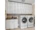 Well-equipped laundry room with modern washer, dryer, sink, and ample cabinet space at 108 Fairbanks Oak Aly # 302, Daniel Island, SC 29492